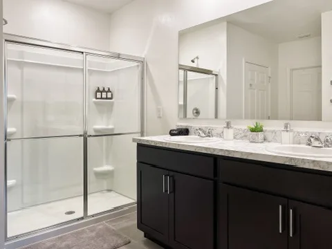 Bathroom at Blue Breeze with a double vanity and a glass-door walk-in shower