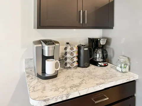 Coffee bar at Blue Breeze with a Keurig, a drip coffee maker, and a stocked selection of pods