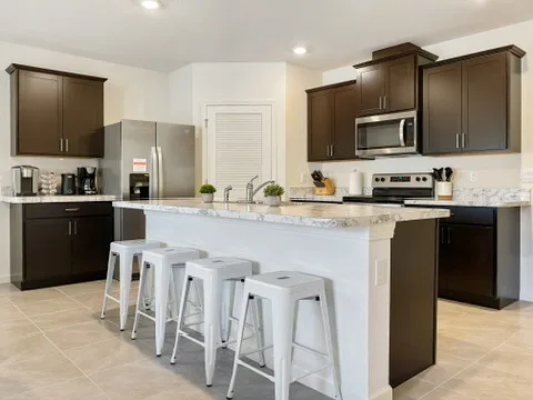 Fully stocked kitchen at Blue Breeze with a large island, bar stools, and stainless steel appliances