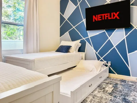 Bedroom at Blue Breeze with two twin beds and a wall-mounted TV